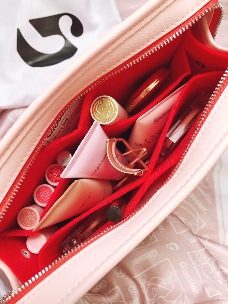 A stylish multi-purpose custom merchandise pouch open to show essentials like lip gloss.